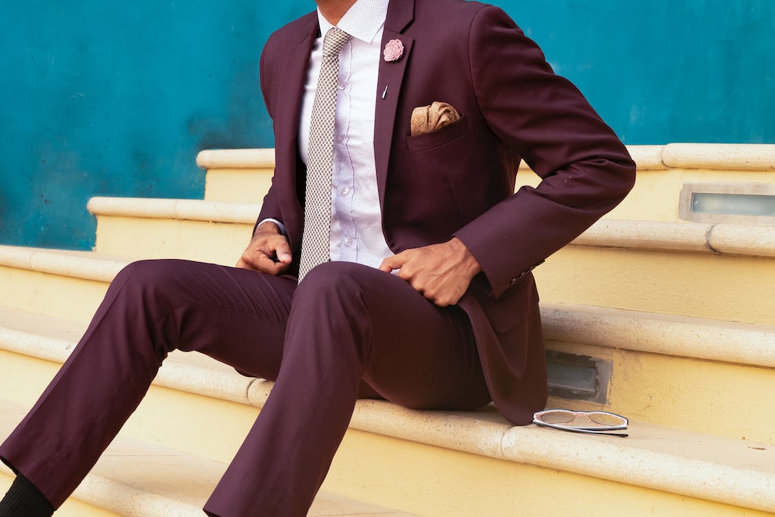 Man sitting on a staircase dressed  in Fashion suit